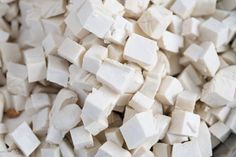 cubes of tofu are in a bowl on the counter top, ready to be cooked