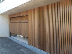 an empty parking lot next to a building with wooden slats on the wall and floor