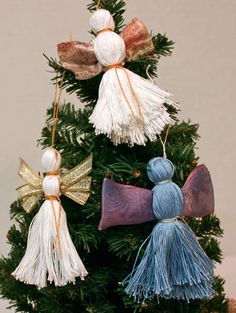 a small christmas tree decorated with tassels and bows