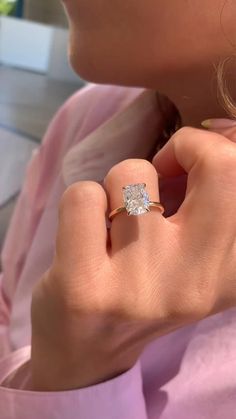 a close up of a person wearing a ring with a diamond on it's finger