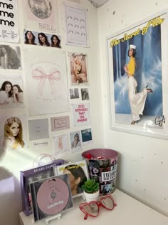 a white desk topped with lots of pictures and posters