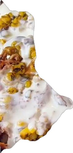 a piece of food that is on top of a white plate with yellow and brown toppings