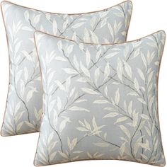 two blue and white pillows with leaves on them