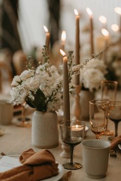 the table is set with white flowers and candles