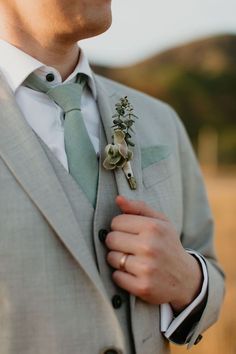 a man wearing a suit and tie with a boutonniere on his lapel