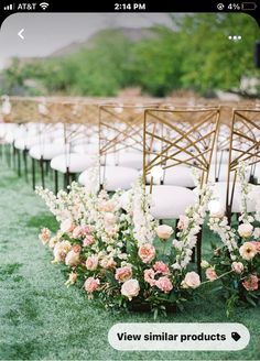 rows of chairs with white and pink flowers on the grass at an outdoor wedding ceremony