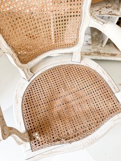 an old white chair with wicker seat and back