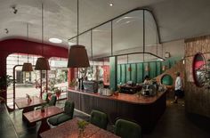 the interior of a restaurant with green chairs and red counter tops, along with large mirrors on the walls