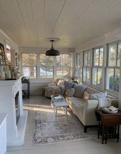 a living room filled with furniture and lots of windows