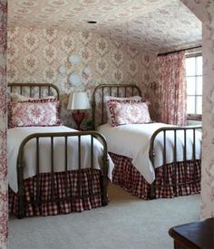 two twin beds in a bedroom with pink and white wallpaper