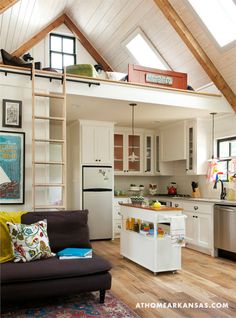 a kitchen and living room are separated by a loft