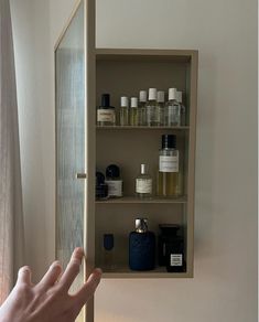 a person's hand is reaching out from behind a shelf