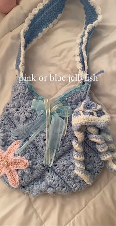 a crocheted purse is laying on a bed with the words pink or blue jellyfish