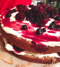 a cake with white frosting and berries on top