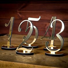 three metal numbers sitting on top of a wooden table