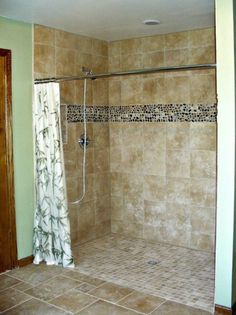 a bathroom with tile flooring and a walk in shower next to a tiled wall