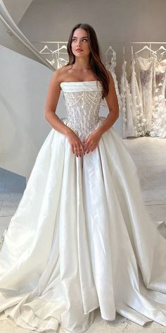 a woman in a white wedding dress posing for the camera