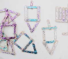 several different shapes and sizes of magnets on a white surface with blue, purple, and pink glitter