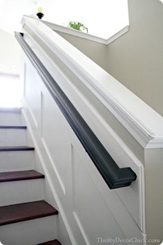 an open door on the side of a white stair case next to a window and wooden steps