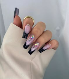 a woman's hand with some black and white nail polishes on her nails