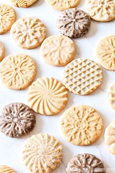 some cookies that are on a white surface and one cookie has been cut in half to look like snowflakes