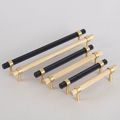 four black and gold door handles on a white background