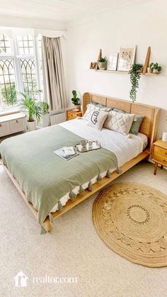 a bedroom with a bed, dressers and potted plants