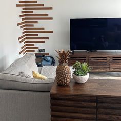 a pineapple sitting on top of a wooden table in front of a flat screen tv