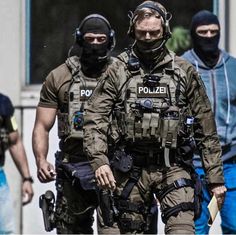 two police officers walking down the street with their faces covered by masks and goggles