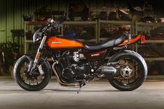 an orange and black motorcycle parked in a garage