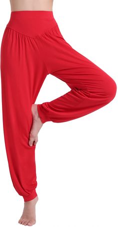 a woman in red pants is doing yoga