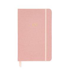 a pink notebook with gold lettering on the front