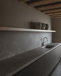 a kitchen sink sitting under a wooden ceiling