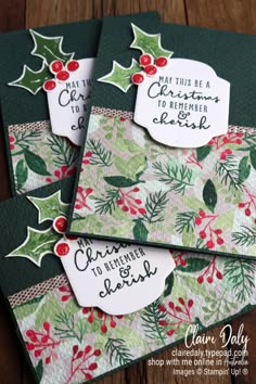 three christmas cards on top of each other, with holly and mist tags attached to them