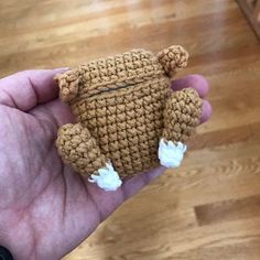 a small crocheted teddy bear is held in the palm of someone's hand