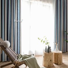 a wooden chair sitting in front of a window next to a potted green plant