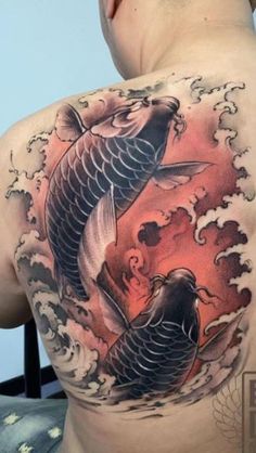 a man with a tattoo on his back is looking at a fish in the water