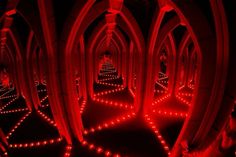 an image of a tunnel with red lights on the floor and arches in the middle