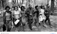 black and white photograph of people walking in the park