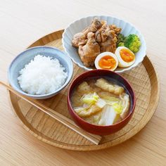 a wooden tray topped with bowls filled with food