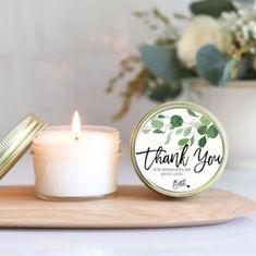 a white candle sitting on top of a wooden tray