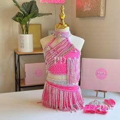 a mannequin dressed in pink and white with beads on it's chest