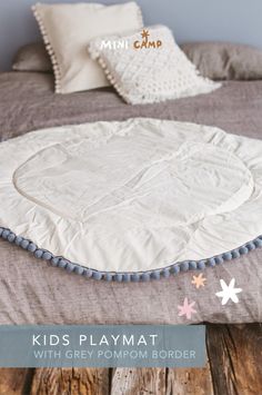 Looking for a stylish addition to your child's nursery? Our MINICAMP Kids Playmat with Grey Pompom Border is perfect! Made from hypoallergenic 100% cotton, this round play mat is safe and soft. It's ideal as a baby gym mat, kids floor rug, or a teepee play mat. The unique grey pompom trim adds a boho touch. Perfect for playrooms, nurseries, and living rooms. Machine washable and certified by Oeko-Tex for safety. Handmade, it fits boho and modern decor styles perfectly. Teepee Nursery, Baby Gym Mat, Round Play Mat, Baby Floor Mat, Nursery Decor Inspiration, Gym Mat, Cozy Reading Corners, Kids Flooring, Tent Decorations