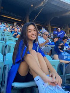 a woman sitting in the stands at a baseball game