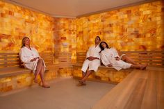 two women in robes sitting on wooden benches