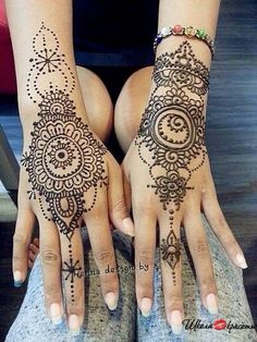 two hands with henna tattoos on them