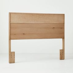 the headboard is made from wood and has two pegs on each side to hold it