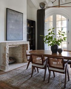 a dining room table with chairs and a potted plant in the middle of it