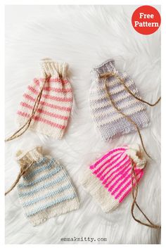 three knitted mittens sitting next to each other on top of a white furnish