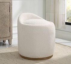 a white chair sitting on top of a rug next to a dresser